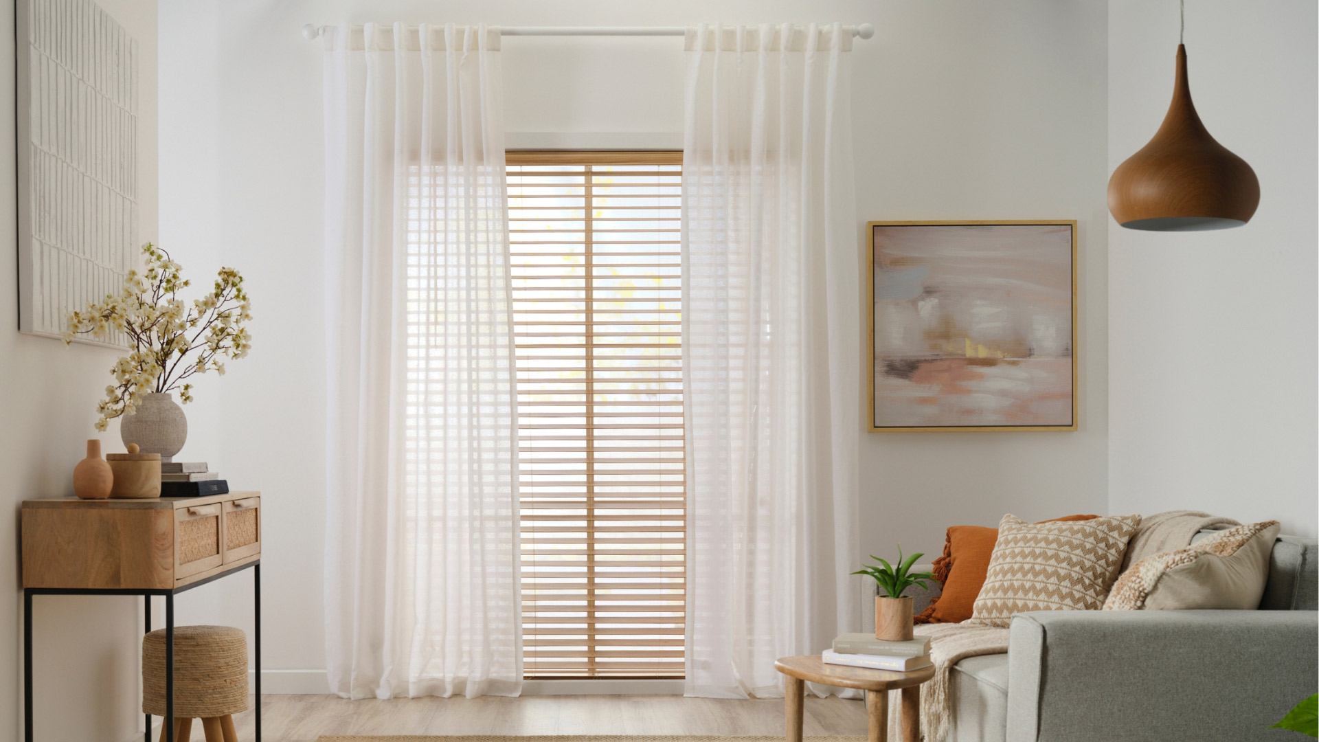 Living room set-up with sheer curtains and timber venetian blinds