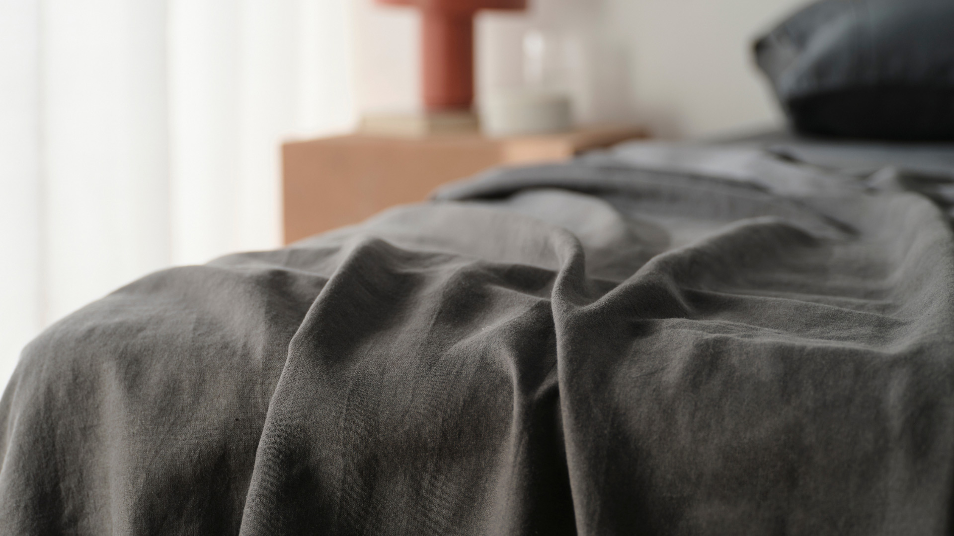 Close up of KOO bed sheets in charcoal grey